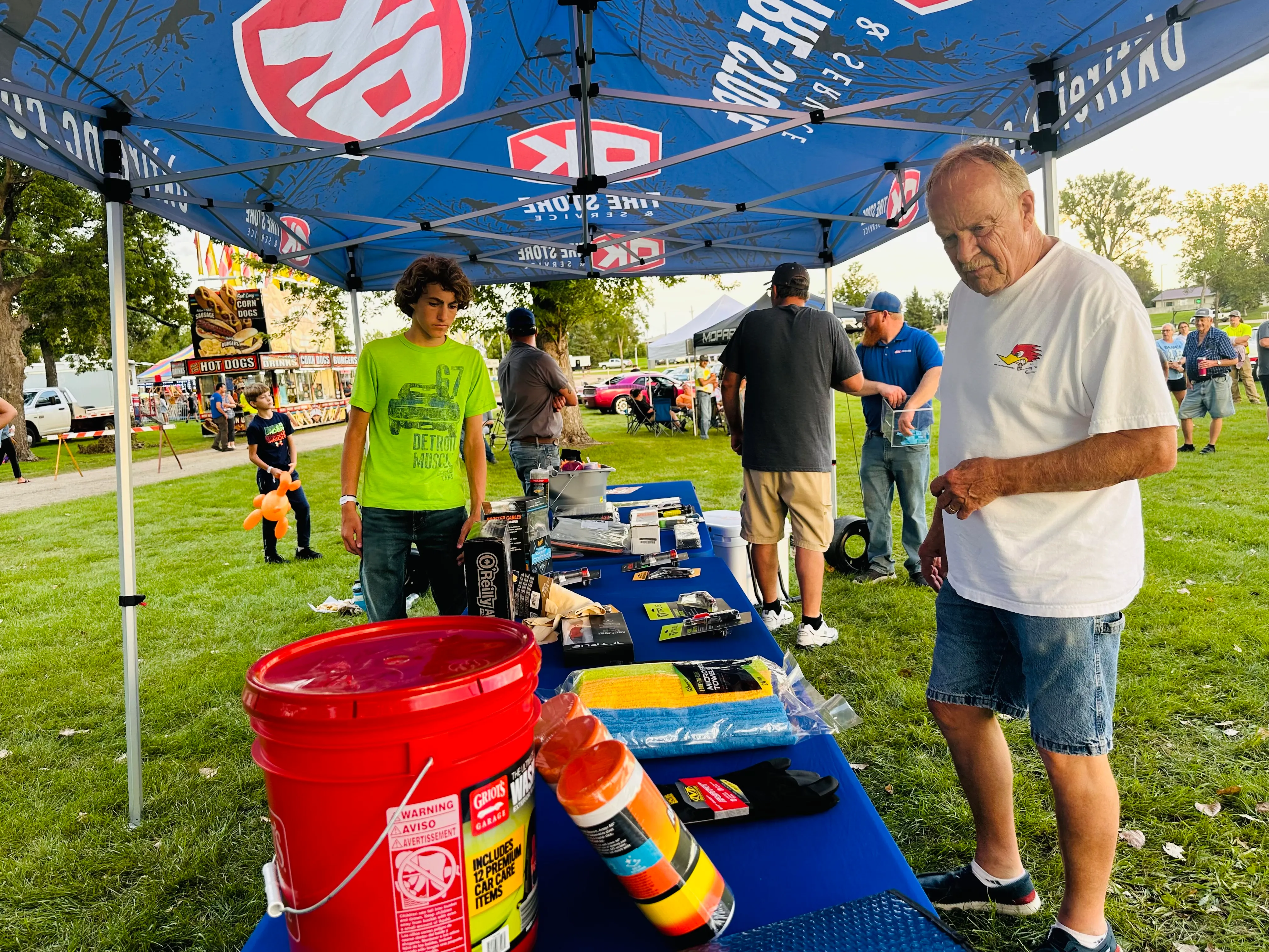 Evening crowd enjoying the event with carnival games in background