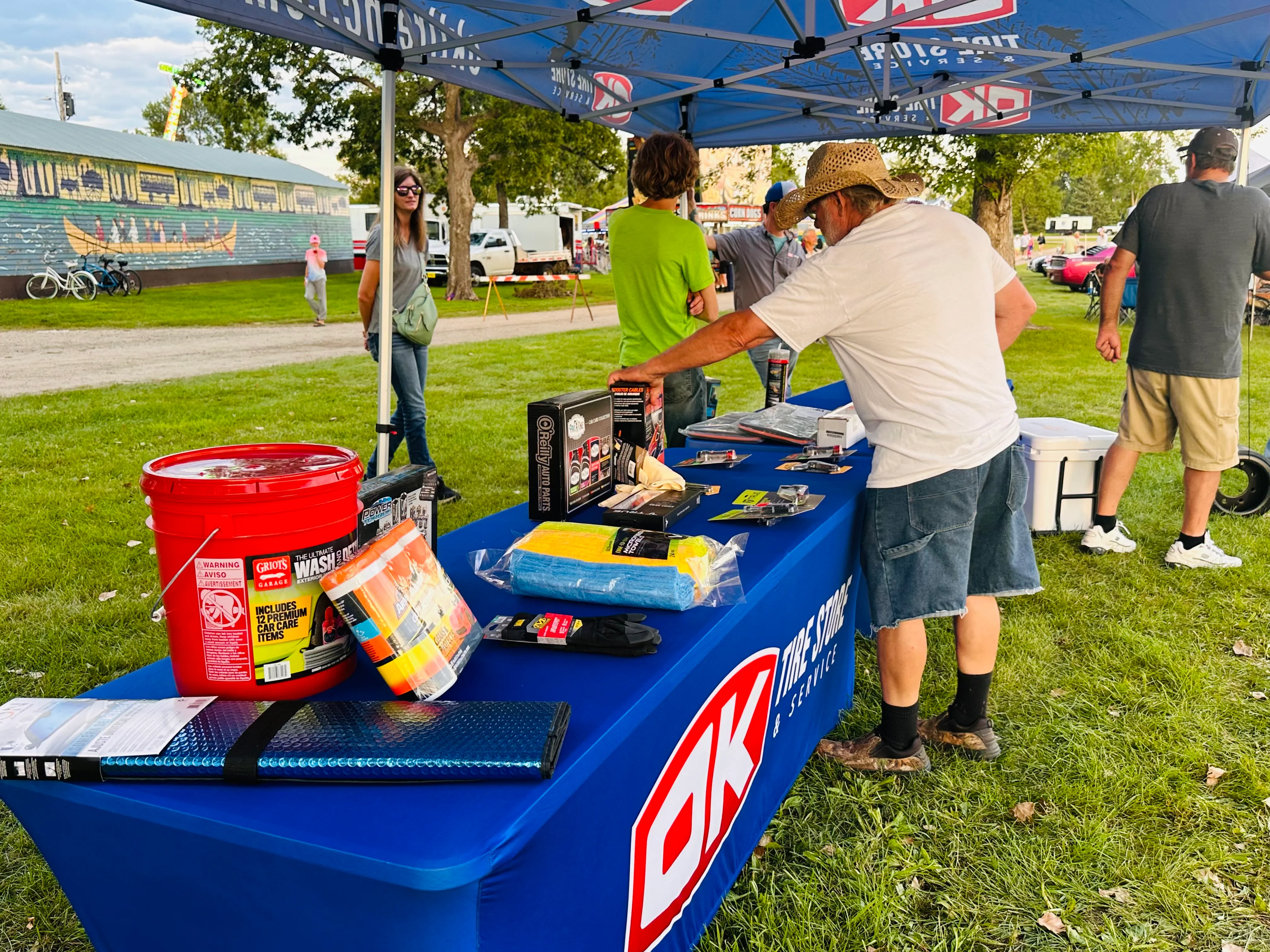 Two OK Tire staff members posing with a Yeti cooler prize at their booth